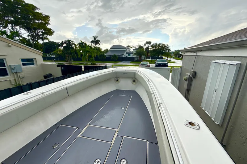 Slide: The Image of 2005 Contender 27 Open boat deck with sleek design, parked in residential area. - 14