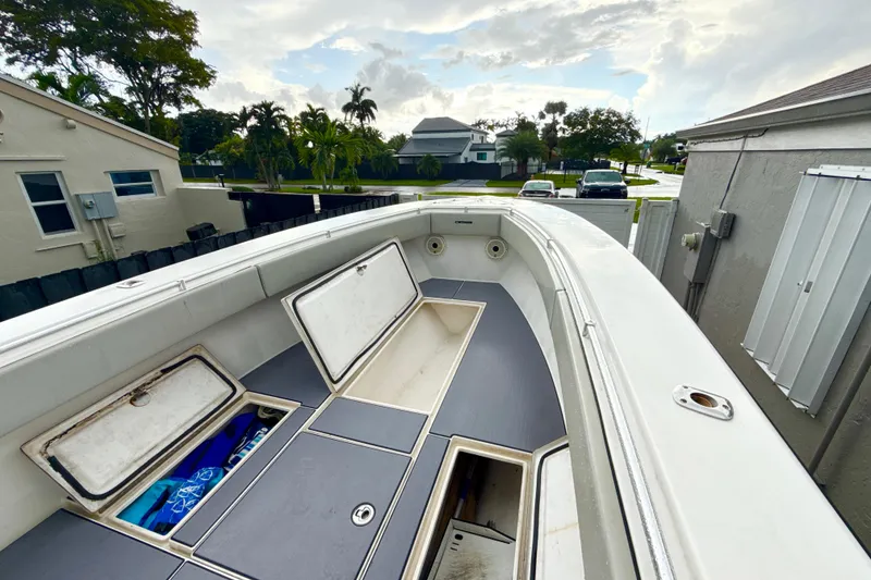 Slide: The Image of 2005 Contender 27 Open boat with open storage compartments, docked near residential area. - 15