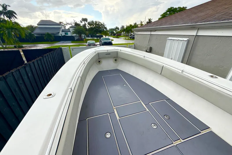 Slide: The Image of 2005 Contender 27 Open boat deck, parked in residential driveway, overcast sky. - 16