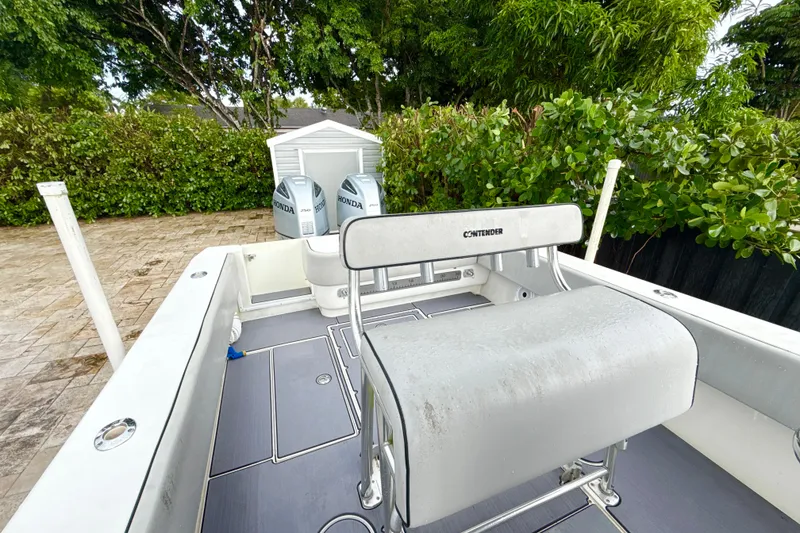 Slide: The Image of 2005 Contender 27 Open boat with Honda engines, parked outdoors near greenery. - 23