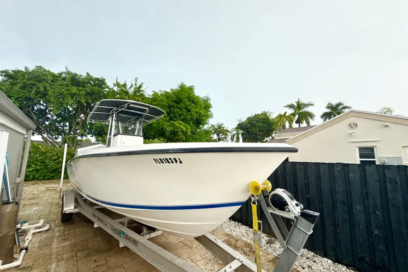 Slide: The Image of 2005 Contender 27 Open boat on trailer, parked outdoors near a house. - 3