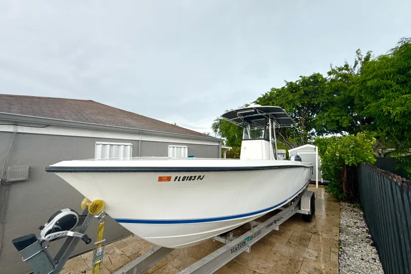 Slide: The Image of 2005 Contender 27 Open boat on trailer, parked beside a house. - 4