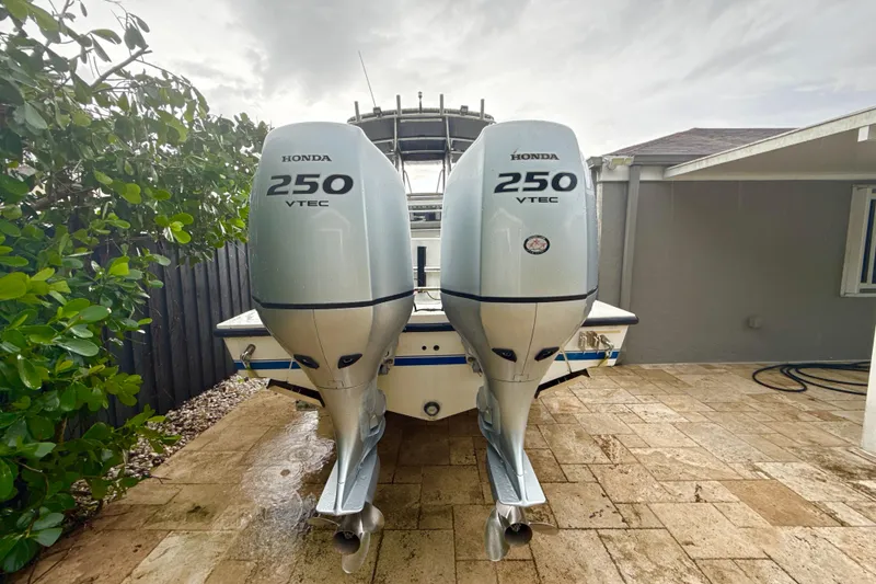 Slide: The Image of 2005 Contender 27 Open boat with dual Honda 250 VTEC outboard engines on a wet patio. - 5