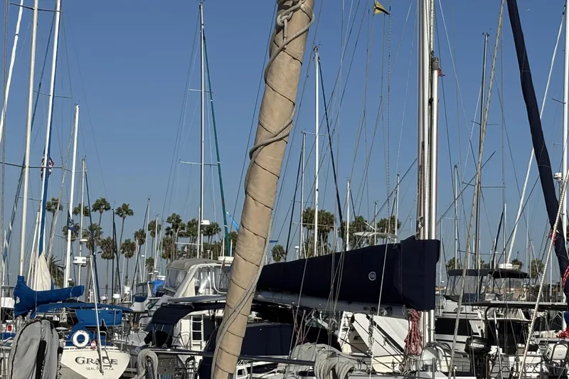 Slide: The Image of 1997 Beneteau Oceanis 400 sailboat docked in a marina with palm trees. - 12