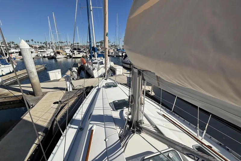 Slide: The Image of 1997 Beneteau Oceanis 400 sailboat docked in a marina under clear blue skies. - 14
