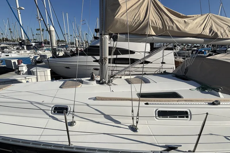 Slide: The Image of 1997 Beneteau Oceanis 400 sailboat docked in a marina under clear blue skies. - 15
