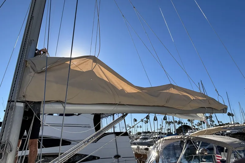 Slide: The Image of 1997 Beneteau Oceanis 400 sailboat with covered mainsail in a sunny marina. - 16