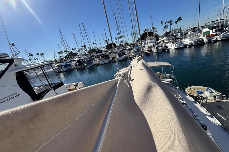 Slide: The Image of Beneteau Oceanis 400 sailboat docked in a sunny marina, surrounded by other boats. - 20
