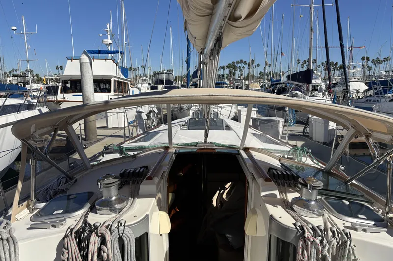 Slide: The Image of 1997 Beneteau Oceanis 400 sailboat docked in a marina, surrounded by other boats. - 39