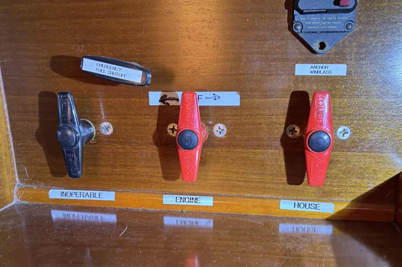 Slide: The Image of Control panel of a 1997 Beneteau Oceanis 400 with labeled switches and emergency fuel shutoff. - 64