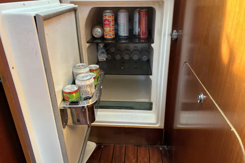 Slide: The Image of Mini fridge on 1997 Beneteau Oceanis 400 yacht, stocked with drinks and water bottles. - 66
