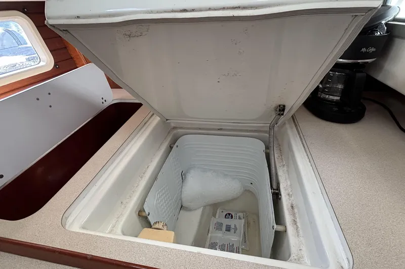 Slide: The Image of Open icebox in 1997 Beneteau Oceanis 400 yacht galley, showing interior storage space. - 67