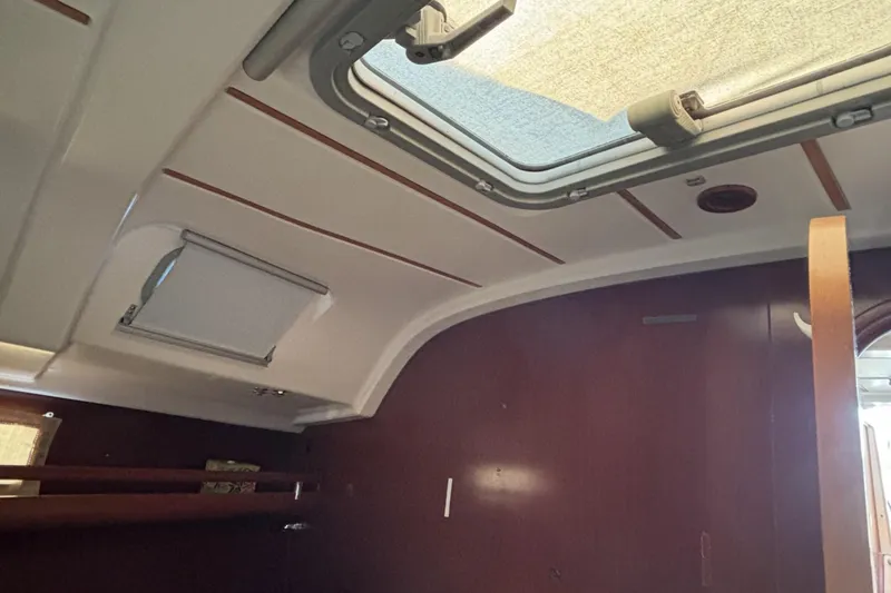 Slide: The Image of Interior cabin view of a 1997 Beneteau Oceanis 400 sailboat, featuring a skylight and wooden paneling. - 75