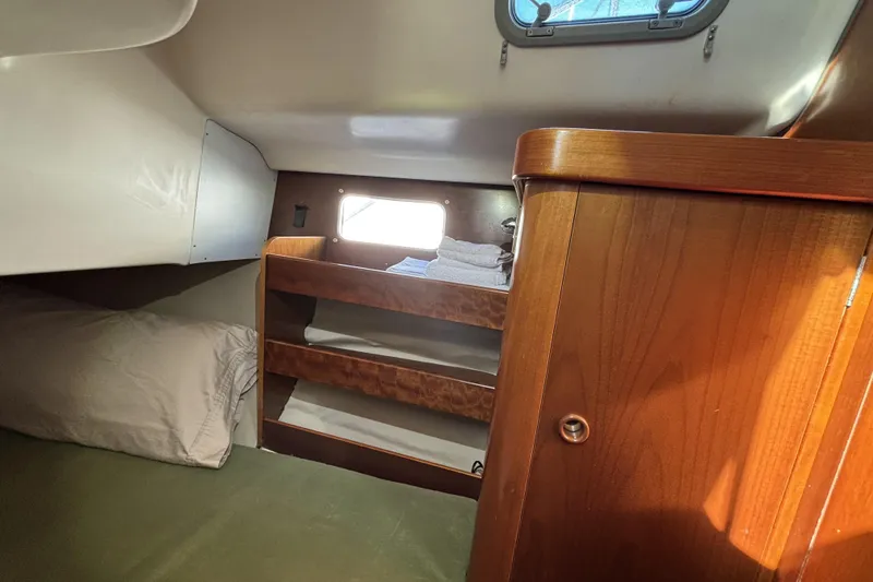 Slide: The Image of Cozy cabin interior of 1997 Beneteau Oceanis 400 sailboat with wooden shelves and bedding. - 81