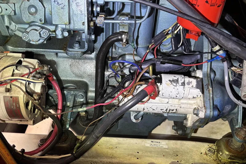 Slide: The Image of Engine components of a 1997 Beneteau Oceanis 400 sailboat, featuring wiring and mechanical parts. - 90