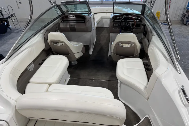 Slide: The Image of 2007 Cobalt 232 boat interior with white seating and steering wheel in a showroom. - 7