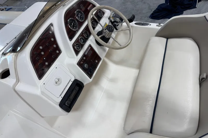 Slide: The Image of 2000 Harris-Kayot 24 Legend boat dashboard with steering wheel and gauges. - 8