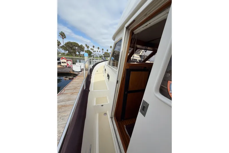 Slide: The Image of 1988 Offshore Yachts 48 Sedan side deck view with open cabin door. - 10