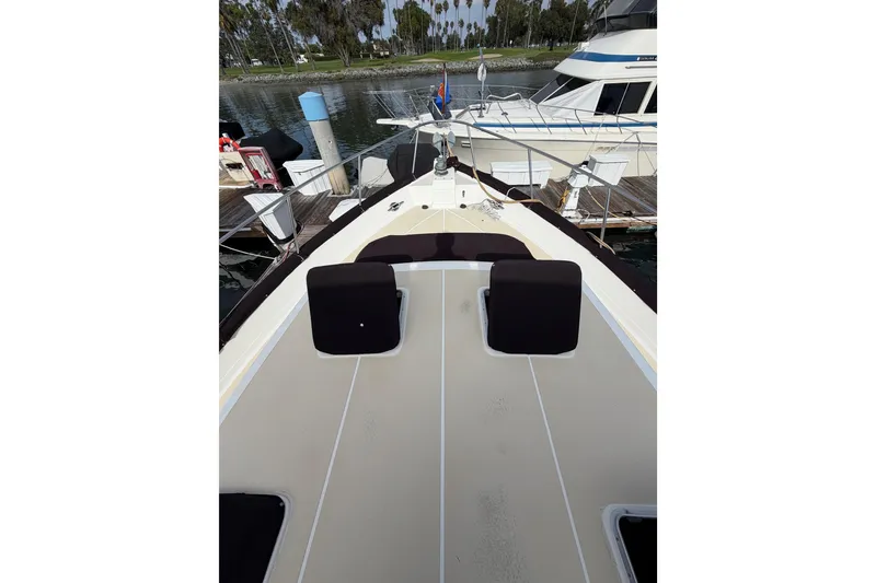 Slide: The Image of 1988 Offshore Yachts 48 Sedan docked, featuring spacious deck and seating area. - 12