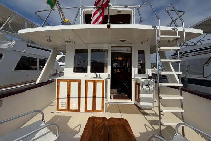 Slide: The Image of 1988 Offshore Yachts 48 Sedan, rear deck view with ladder and seating area. - 18