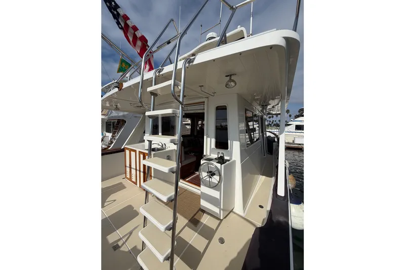 Slide: The Image of 1988 Offshore Yachts 48 Sedan with ladder and deck, docked at marina. - 19