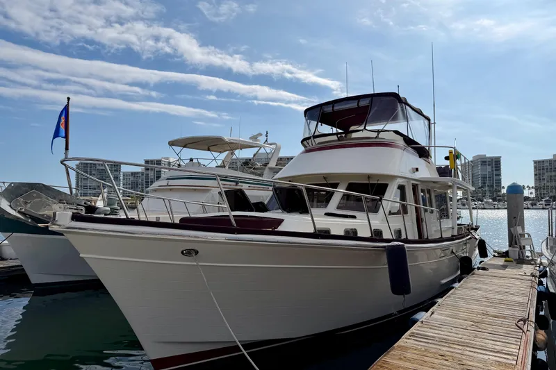 Slide: The Image of 1988 Offshore Yachts 48 Sedan docked at marina under clear blue sky. - 2
