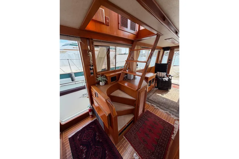 Slide: The Image of Interior of 1988 Offshore Yachts 48 Sedan with wooden stairs and cozy seating area. - 33