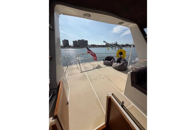 Slide: The Image of 1988 Offshore Yachts 48 Sedan deck view with bean bags and American flag. - 34