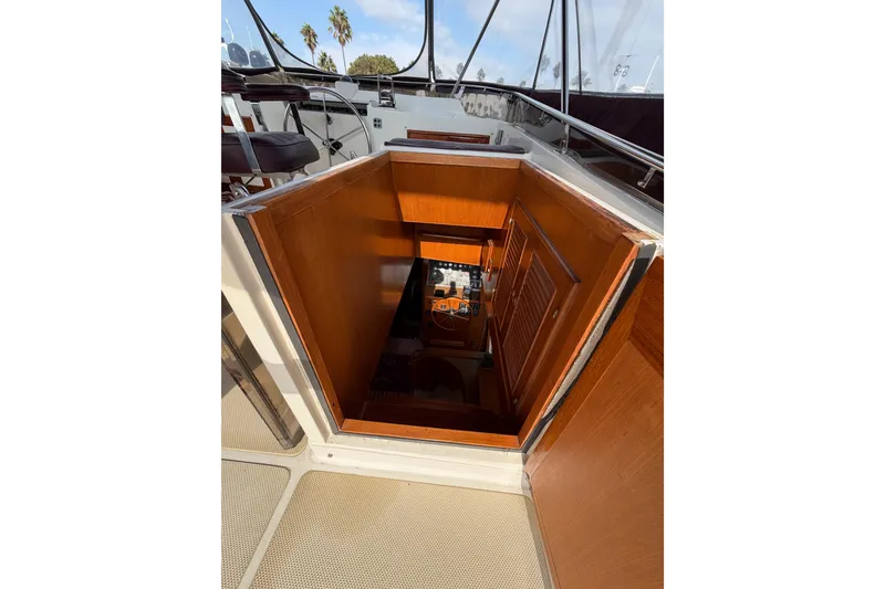 Slide: The Image of 1988 Offshore Yachts 48 Sedan interior view with wooden stairs and cabin entrance. - 43