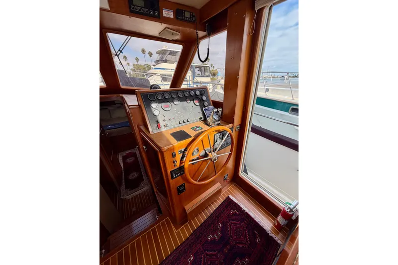 Slide: The Image of 1988 Offshore Yachts 48 Sedan helm with wooden steering wheel and control panel. - 45