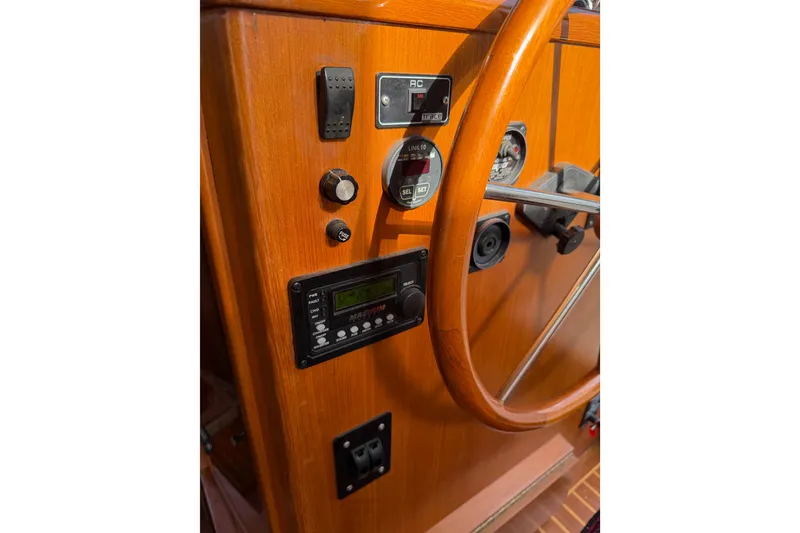 Slide: The Image of 1988 Offshore Yachts 48 Sedan helm with wooden wheel and control panel. - 47