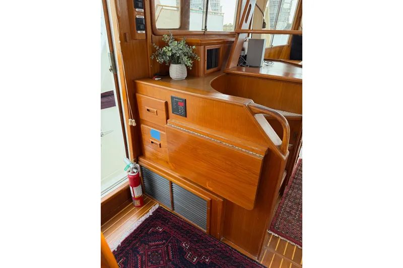 Slide: The Image of 1988 Offshore Yachts 48 Sedan interior with wooden cabinetry and fire extinguisher. - 54