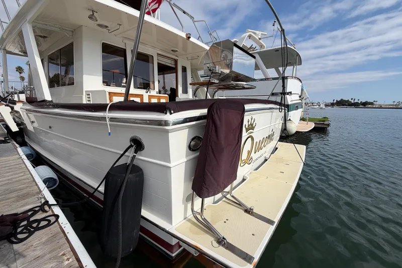 Slide: The Image of 1988 Offshore Yachts 48 Sedan docked, featuring spacious deck and elegant design. - 6