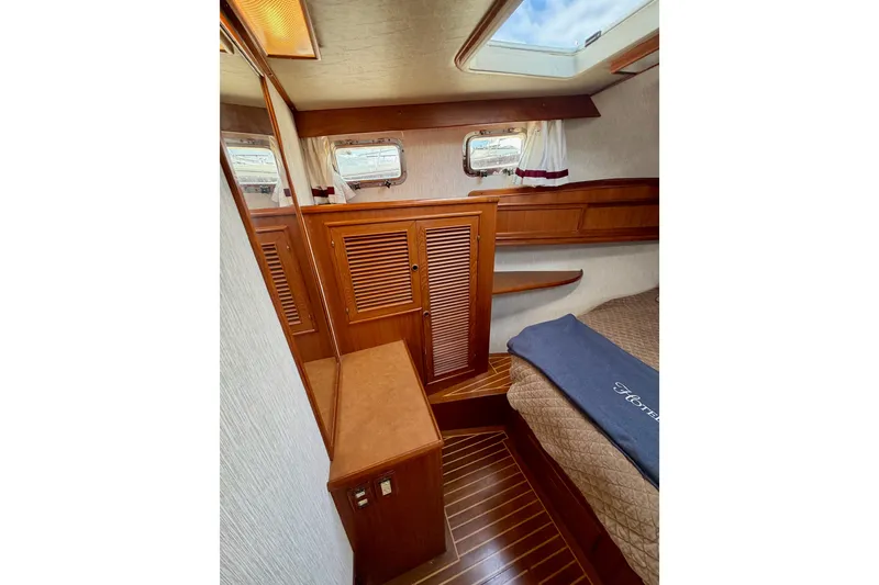Slide: The Image of 1988 Offshore Yachts 48 Sedan cabin interior with wood paneling and skylight. - 66