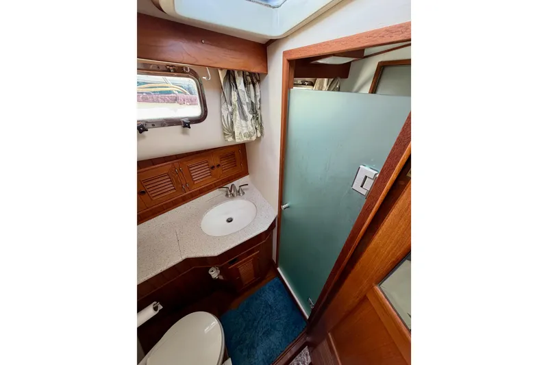Slide: The Image of 1988 Offshore Yachts 48 Sedan bathroom with sink, toilet, and shower. - 69