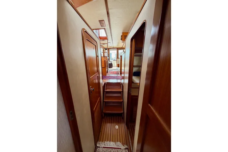 Slide: The Image of Interior hallway of 1988 Offshore Yachts 48 Sedan, featuring wooden doors and steps. - 71
