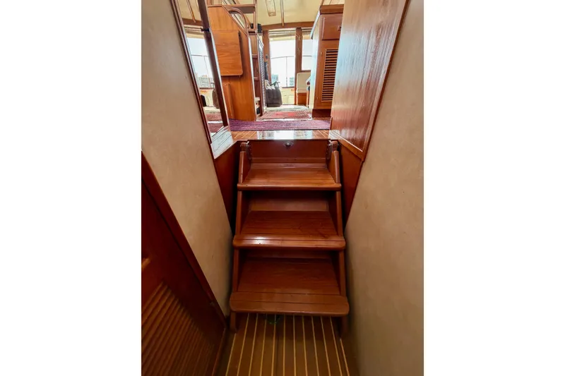 Slide: The Image of Staircase inside 1988 Offshore Yachts 48 Sedan, featuring polished wooden steps and interior. - 72
