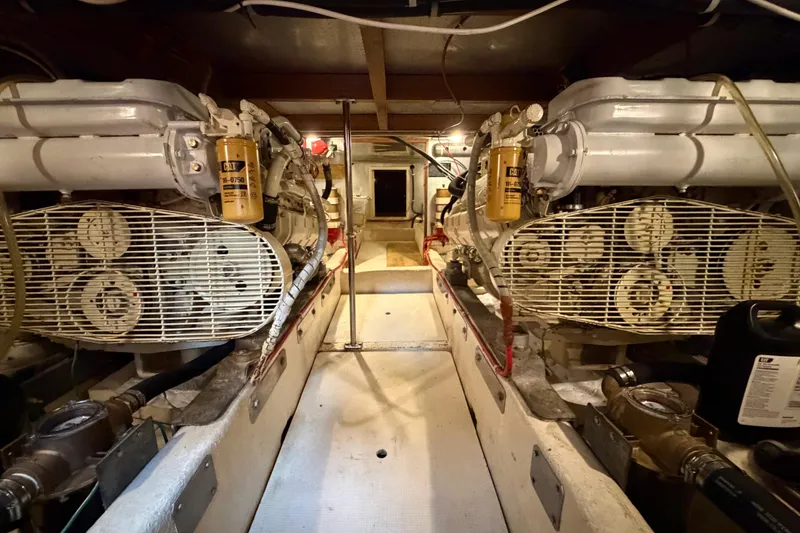 Slide: The Image of Engine room of 1988 Offshore Yachts 48 Sedan, featuring dual engines and mechanical components. - 77
