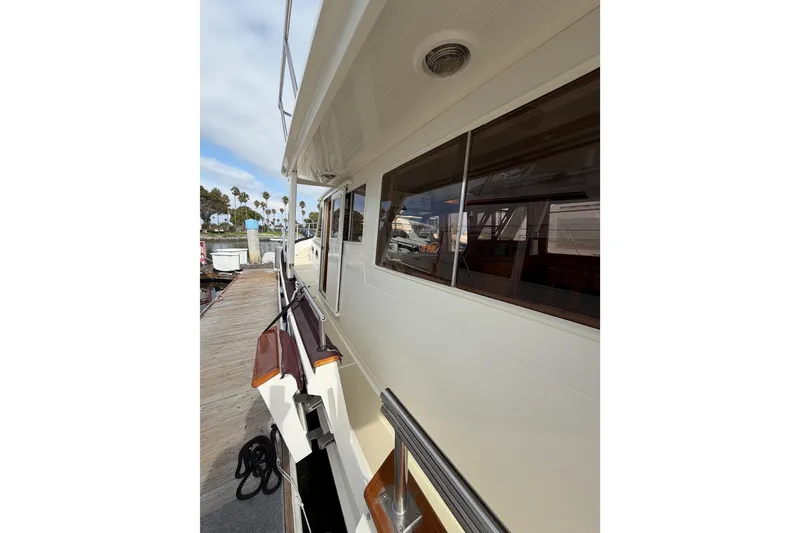 Slide: The Image of 1988 Offshore Yachts 48 Sedan docked, showcasing side view and windows. - 8