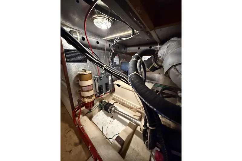 Slide: The Image of Engine room of 1988 Offshore Yachts 48 Sedan with visible components and wiring. - 80