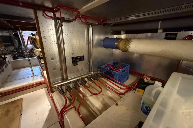 Slide: The Image of Engine room of 1988 Offshore Yachts 48 Sedan with visible piping and equipment. - 84