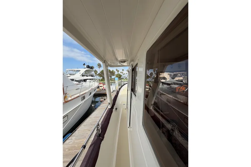 Slide: The Image of 1988 Offshore Yachts 48 Sedan docked, showcasing side deck and marina view. - 9