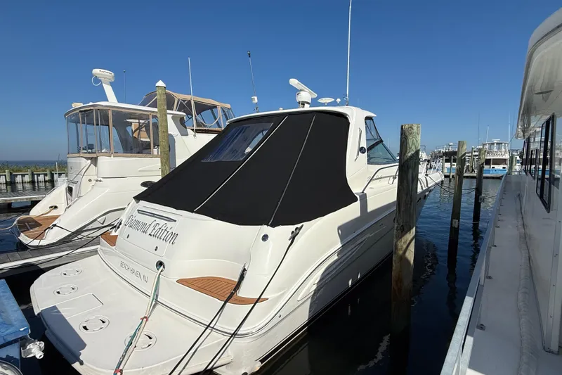 Slide: The Image of Luxurious interior of 2003 Sea Ray 460 Sundancer yacht with white seating and wood accents. - 12