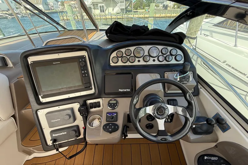 Slide: The Image of 2008 Cruisers Yachts 420 Express helm with navigation controls and steering wheel. - 22