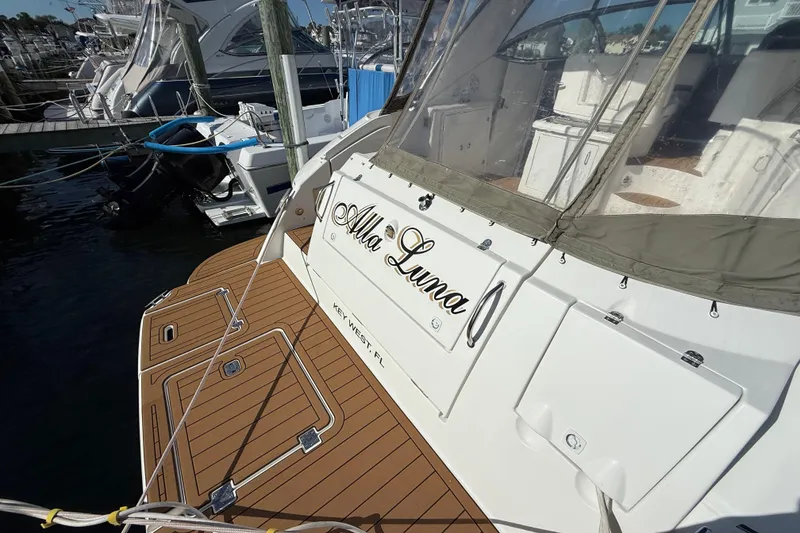 Slide: The Image of 2008 Cruisers Yachts 420 Express docked, featuring teak deck and covered seating area. - 15