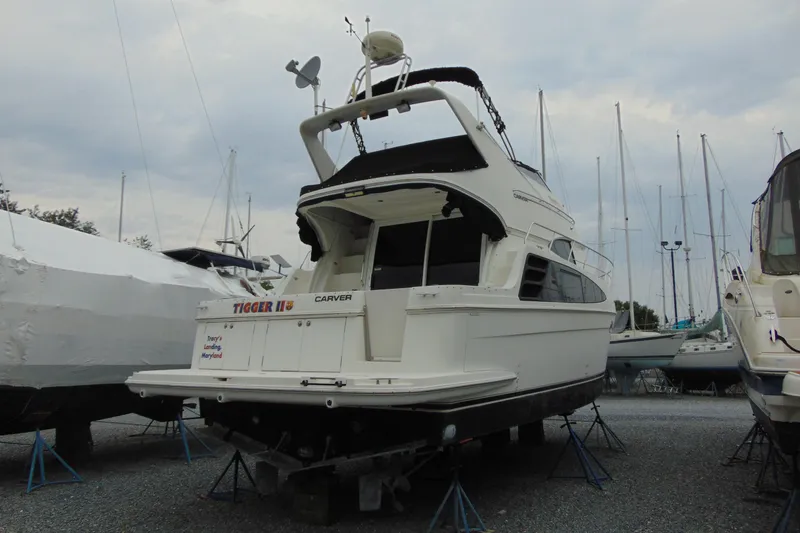 Slide: The Image of 2003 Carver 360 Sport Sedan yacht on stands in a marina, surrounded by other boats. - 2