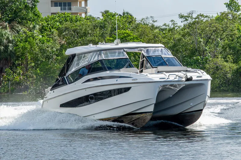The Image of 2023 Aquila 32 Power Cat cruising on a scenic waterway. - 0