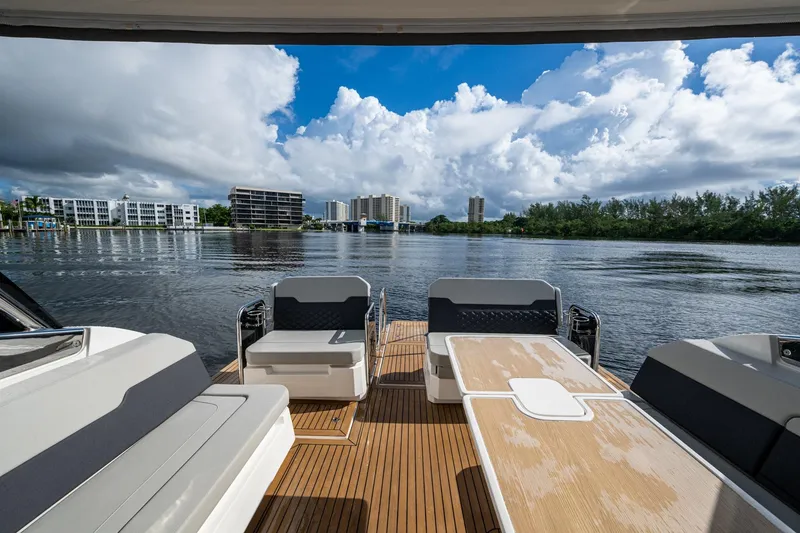 Slide: The Image of Aquila 32 Power Cat 2023, spacious deck with seating, overlooking serene waterfront and skyline. - 27