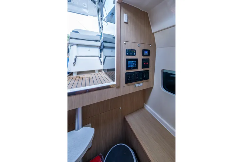 Slide: The Image of Interior view of 2023 Aquila 32 Power Cat, featuring control panel and seating area. - 3
