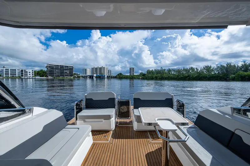 Slide: The Image of Aquila 32 Power Cat 2023, spacious deck view, modern seating, scenic waterfront backdrop. - 31